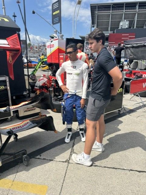 Ben and his driver in the IndyCar pit lane, front wing assemblies in the foreground
